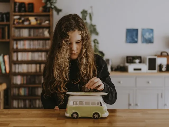 niña metiendo moneda en alcancia