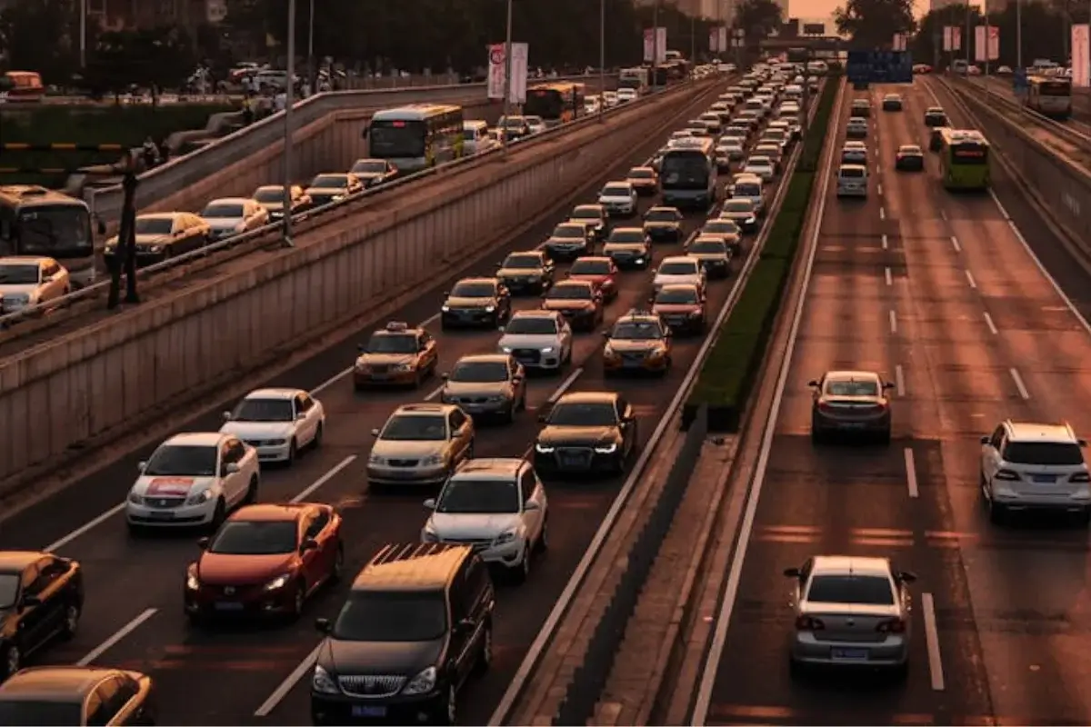 Carros uno detrás del otro en una autopista, la luz es la del ocaso