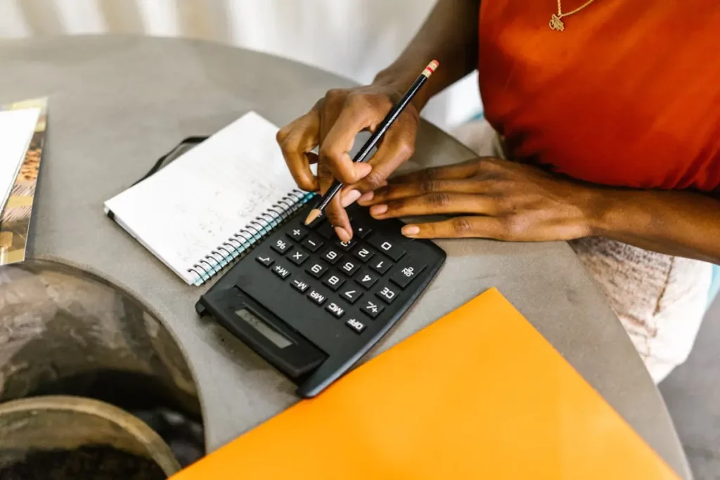 Mujer con una calculadora y una libreta de notas