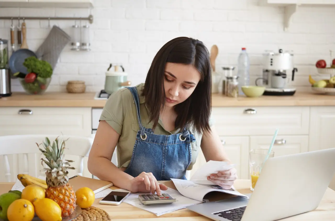 Mujer en una cocina calcula su hipoteca