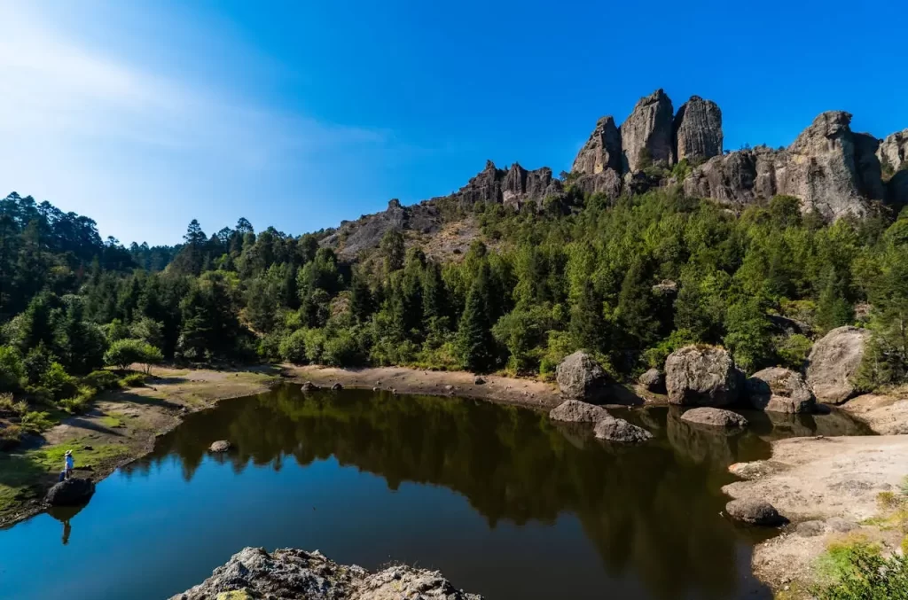 Paisaje natural donde se ve un cuerpo de agua, rocas y vegetación